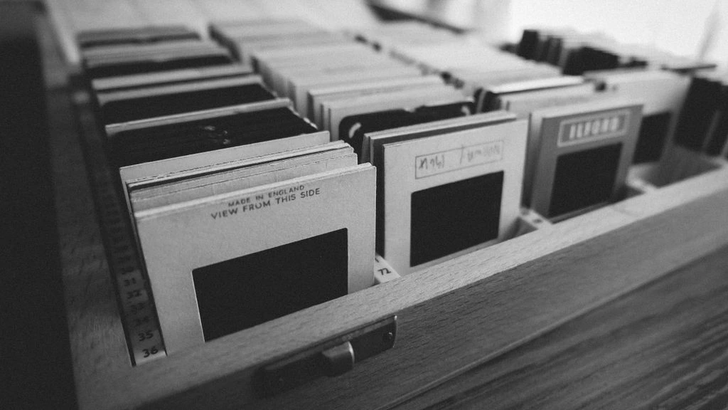 Rows of labelled archival sleeves inside a climate-controlled library storage vault.